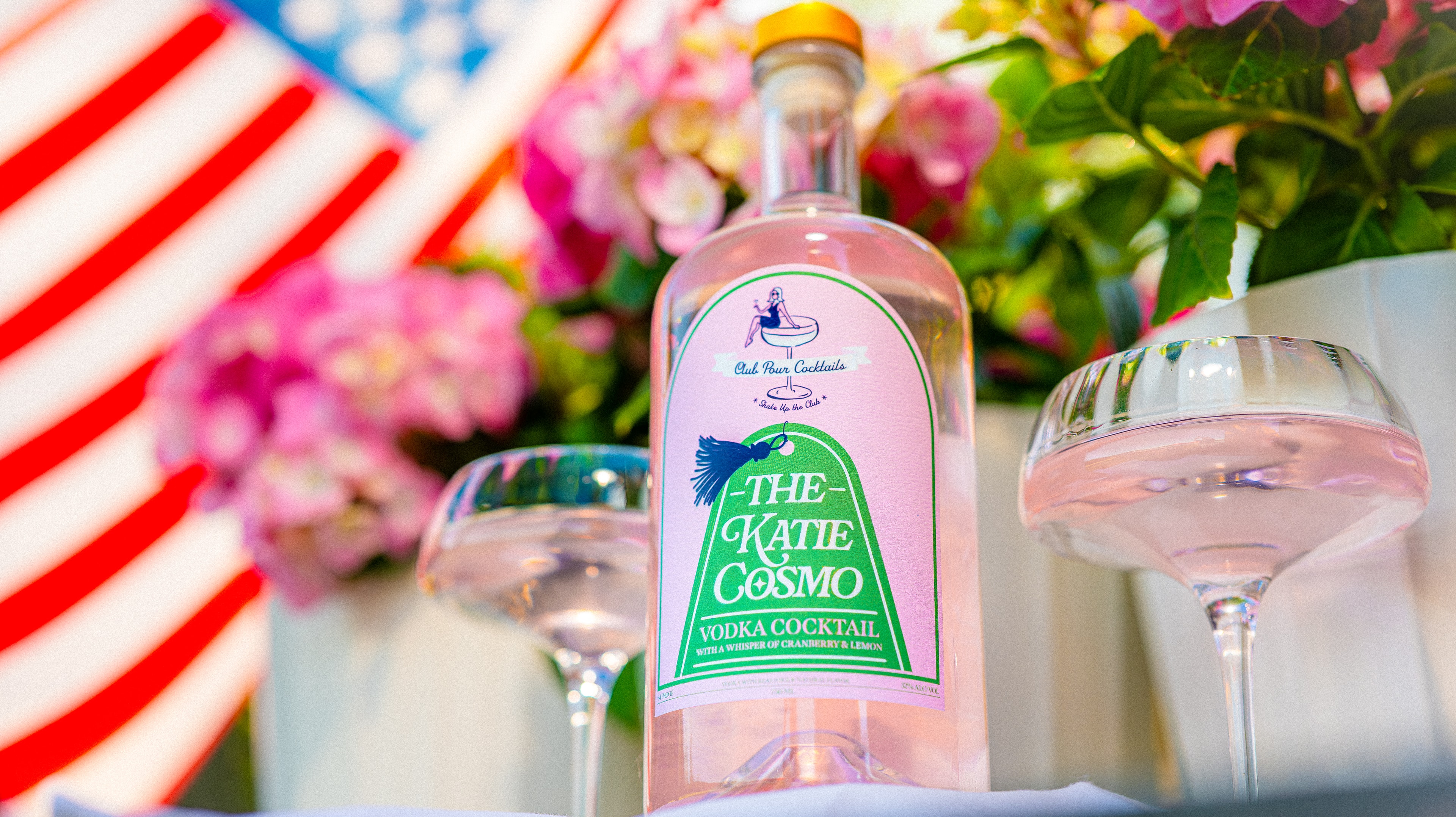 Katie Cosmo bottle styled with hydrangeas and flowers outdoors